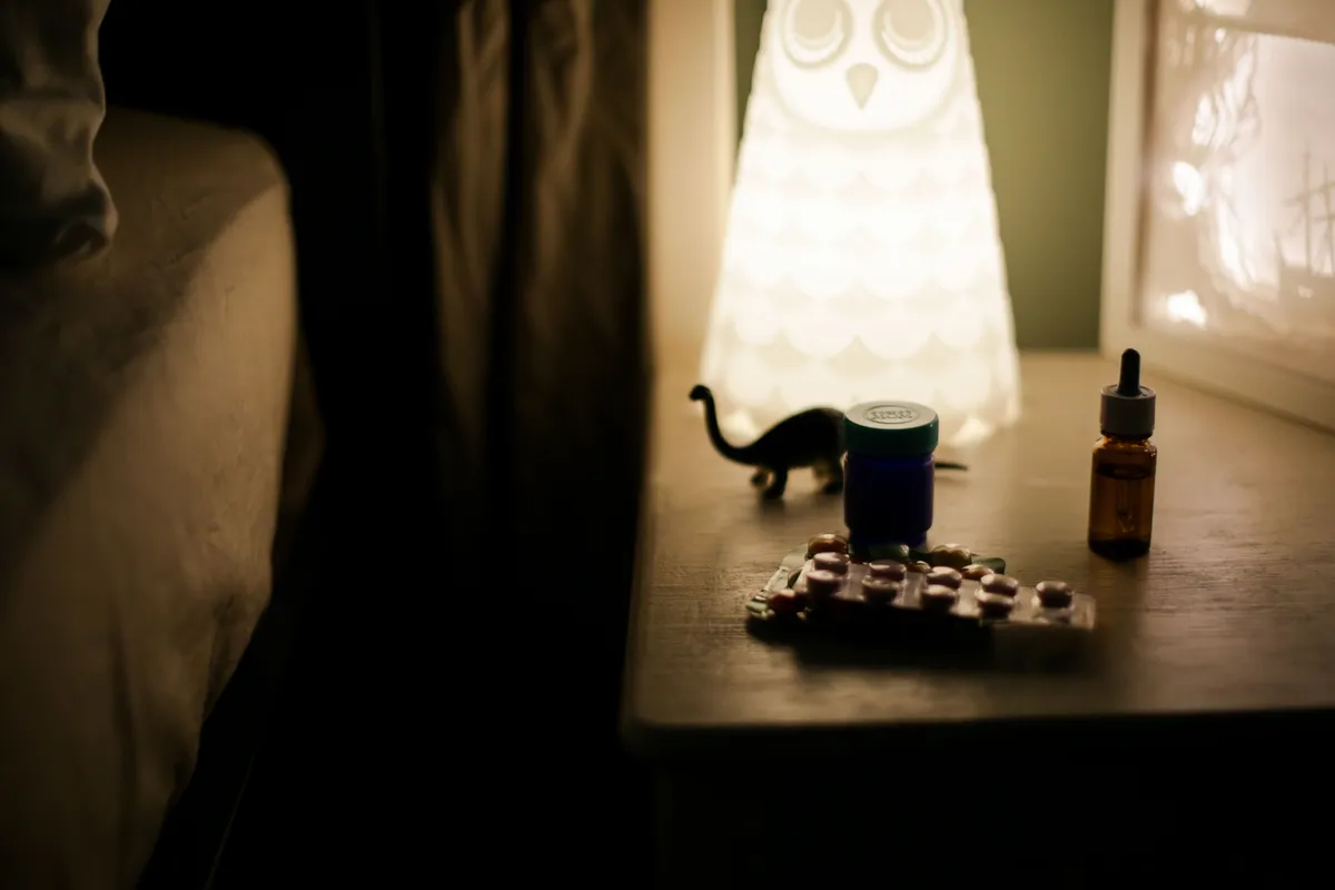 A cozy bedside table at night with a soft lamp and a supplement bottle — an evening magnesium routine.