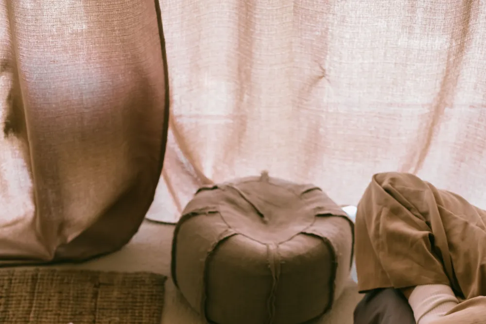A woman's legs resting calmly on a bed in soft, warm light.